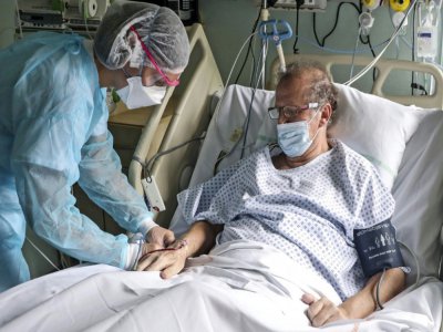 Une soignante s'occupe de Jean-Michel Girardot, atteint par le coronavirus, dans l'unité de soins de surveillance continue de l'hôpital Emile Muller, le 29 avril 2020 à Mulhouse - SEBASTIEN BOZON [AFP]