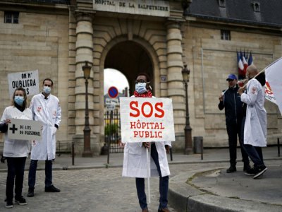 Des personnels soignants et membres du syndicat CGT manifestent devant l'hôpital public de La Pitié-Salpêtrière, le 30 avril 2020 à la veille du 1er mai - THOMAS COEX [AFP]