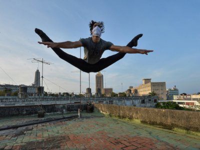 Le danseur Adrián Sánchez, premier soliste du Ballet national cubain, s'exerce sur le toit de sa maison, le 21 avril 2020 à La Havane - YAMIL LAGE [AFP]