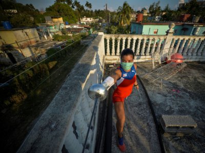 La pentathlonienne Leydi Laura Moya s'entraîne à l'épée au pistolet sur le toit de sa maison, le 23 avril 2020 à La Havane, à Cuba - YAMIL LAGE [AFP]