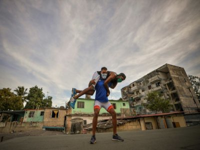 Daniel Grégorich, champion de lutte gréco-romaine, s'entraîne avec un ami sur le toit de sa maison, le 20 avril 2020 à La Havane, à Cuba - YAMIL LAGE [AFP]