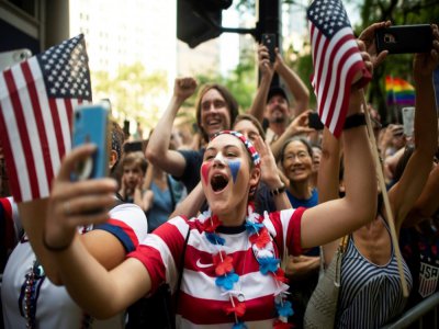 Des supporters de l'équipe de football féminine américaine lors de la parade après leur succès en Coupe du monde, à New York le 10 juillet 2019 - Johannes EISELE [AFP/Archives]