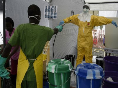 Un soignant de l'ONG Médecins sans frontières (MSF) est désinfecté en sortant d'un centre de traitement de malades atteints du virus Ebola en septembre 2014 à Monrovia, au Liberia - PASCAL GUYOT [AFP/Archives]