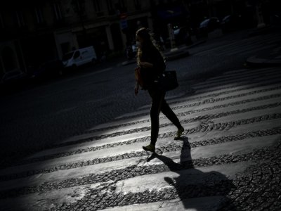 Une femme traverse une rue déserte, le 21 avril 2020 à Paris, pendant le confinement instauré en France pour lutter contre l'épidémie de coronavirus - Christophe ARCHAMBAULT [AFP/Archives]
