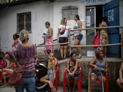 Des femmes font la queue pour une distribution de nourriture dans une favela de Rio de Janeiro, le 7 avril 2020 au Brésil - MAURO PIMENTEL [AFP/Archives]