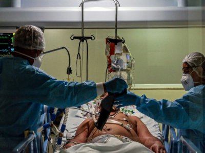 Des personnels soignants s'occupent d'un patient atteint du coronavirus dans une unité de soins intensifs à l'hôpital Emilio Ribas de Sao Paulo, le 20 avril 2020 au Brésil - Miguel SCHINCARIOL [AFP/Archives]