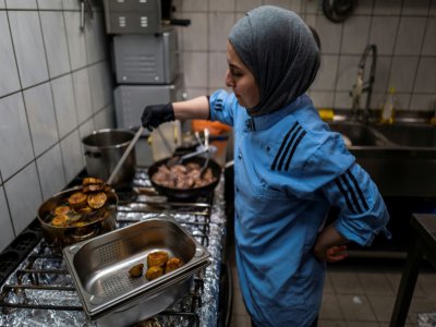 La chef cuisinière syrienne Malakeh Jazmati, devant les fourneaux de son restaurant, prépare des repas gratuits pour les salariés des supermarchés, le 21 avril 2020 à Berlin, en Allemagne - John MACDOUGALL [AFP]