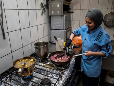 La chef cuisinière syrienne Malakeh Jazmati, devant les fourneaux de son restaurant, prépare des repas gratuits pour les salariés des supermarchés, le 21 avril 2020 à Berlin, en Allemagne - John MACDOUGALL [AFP]