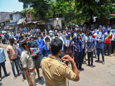 Un policier (C) parle à des migrants qui veulent s'inscrire pour pouvoir être transférés dans leurs villages, à Mumbai (Inde) le 2 mai 2020 - INDRANIL MUKHERJEE [AFP]