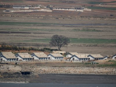 Des champs et des baraquements en Corée du Nord, vus depuis la Zone démilitarisée (DMZ), le 23 avril 2020 à Ganghwa-gun, en Corée du Sud - Ed JONES [AFP/Archives]
