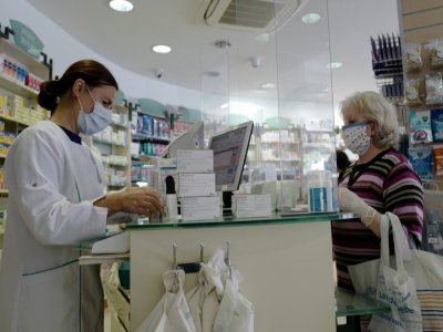 Dans une pharmacie de Nice, des panneaux de plastique ont été installés pour protéger personnel et clients - VALERY HACHE [AFP]
