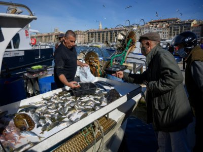 Un client portant un masque de protection achète du poisson à Marseille, le 3 mai 2020 - Christophe SIMON [AFP]