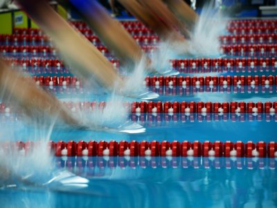 Des nageurs plongent lors des séries du 400 m quatre bages des Jeux asiatiques 2018 le 22 août 2018 à Jakarta. - Martin BUREAU [AFP/Archives]