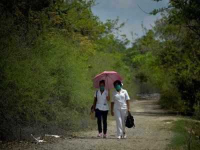 Une infirmière et une étudiante en médecine font du porte-à-porte pour détecter des cas de coronavirus, le 28 avril 2020 à Zaragoza, à Cuba - YAMIL LAGE [AFP/Archives]