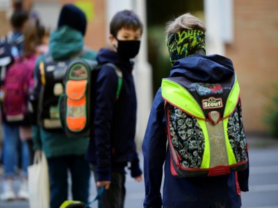 Des enfants font la queue en respectant une distance de sécurité entre eux, à l'école élémentaire Petri à Dortmund, en Allemagne, le 7 mai 2020 - Ina FASSBENDER [AFP]