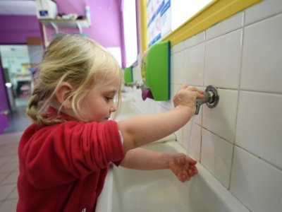 Une élève se lave les mains dans une école à Saint-Aubin-du-Cormier en France le 7 mai 2020 - JEAN-FRANCOIS MONIER [AFP]
