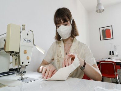 Capucine, élève d'une école de mode fabrique un masque à Paris, chez elle le 8 mai 2020 - GEOFFROY VAN DER HASSELT [AFP]