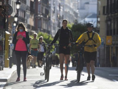 Des personnes marchent ou font du sport dans une rue de Madrid pendant les heures autorisées, le 10 mai 2020 en Espagne - PIERRE-PHILIPPE MARCOU [AFP]