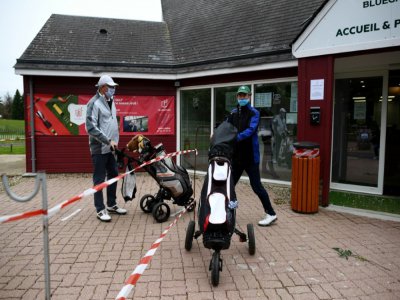 Des golfeurs portant des masques, à l'entrée du parcours, sécurisé, de Saint-Aubin, dans l'Essonne, le 11 mai 2020 - FRANCK FIFE [AFP]