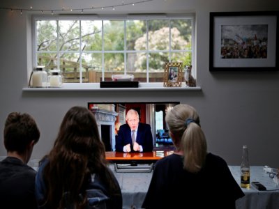 Une famille devant la télévision pour écouter le Premier ministre Boris Johnson présenter les grandes lignes du déconfinement, prés de Londres le 10 mai 2020 - ADRIAN DENNIS [AFP]