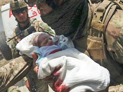 Un membre des forces de sécurité afghane porte un nouveau-né évacué d'un hôpital attaqué par des hommes armés, le 12 mai 2020 à Kaoul - STR [AFP]