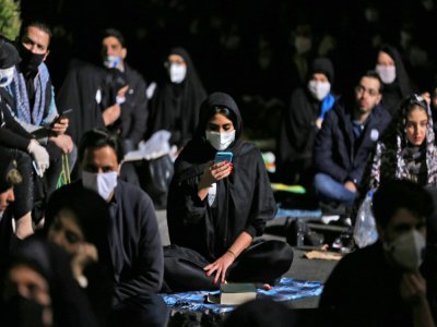 Des Iraniens portant des masques sanitaires prient pendant la "Nuit du Destin", à Téhéran, le 13 mai 2019 - ATTA KENARE [AFP]