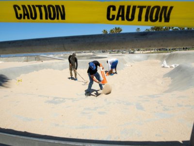 Des skateurs nettoient le skate park de Venice Beach (Etats-Unis), auparavant empli de sable pour éviter tout rassemblement, le 13 mai 2020 - VALERIE MACON [AFP]