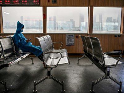 Un homme portant des vêtements de protection emprunte un ferry traversant le fleuve Yangtsé, à Wuhan, en Chine, le 14 mai 2020. - Hector RETAMAL [AFP]