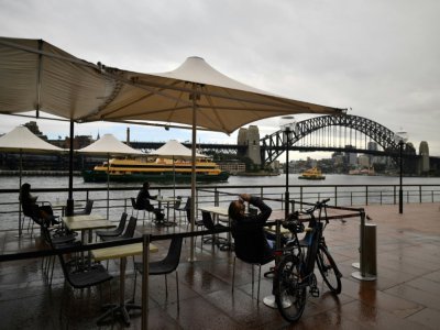 Des clients à la terrasse d'un café sur le port de Sydney, après sept semaines de restrictions dues à la pandémie de nouveau coronavirus, le 15 mai 2020 - Saeed KHAN [AFP]
