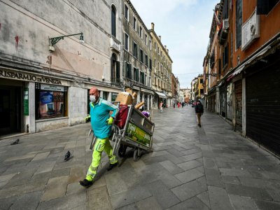 Un employé de la municipalité dans le quartier Cannareggio, à Venise, transporte des ordures, le 13 mai 2020 - Vincenzo PINTO [AFP]