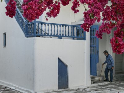 Une personne âgée rentre chez lui dans sa maison à Mykonos, ile grecque des Cyclades, le 13 mai 2020 - ARIS MESSINIS [AFP]