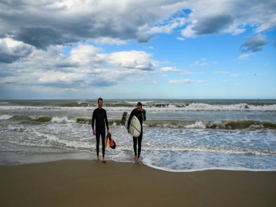 Des surfeurs sur la plage de Rimini, le 11 mai 2020 en Italie - Vincenzo PINTO [AFP]
