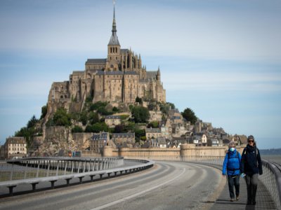 Des promeneurs sur la route conduisant au Mont Saint-Michel, le 12 mai 2020 au lendemain du déconfinement en France - LOU BENOIST [AFP]