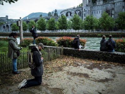 Des pèlerins devant la basilique Notre-Dame du Rosaire avant la réouverture du sanctuaire de Lourdes, fermé pour la première fois de son histoire pendant deux mois, pour cause d'épidémie, le 16 mai 2020 à Lourdes - Lionel BONAVENTURE [AFP]