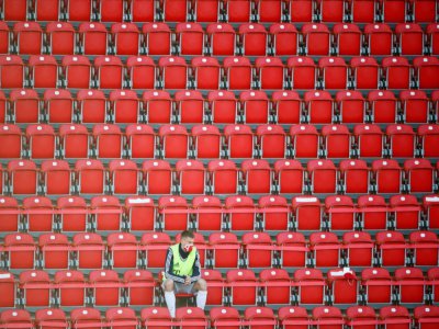 Un remplaçant du Bayern masqué est installé seul dans une tribune lors du match entre son équipe et l'Union Berlin, le 17 mai 2020. - HANNIBAL HANSCHKE [POOL/AFP]