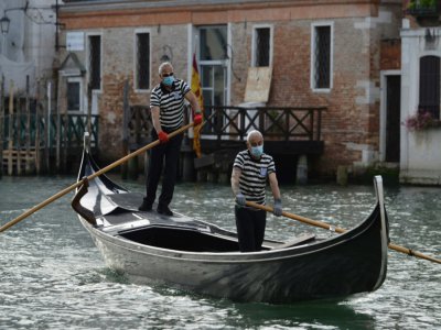 Des gondoliers, le visage masqué pour se prémunir du coronavirus, reprennent le travail à Venise après le confinement, le 18 mai 2020 - ANDREA PATTARO [AFP]