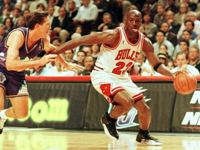 Michael Jordan dans son attitude caractéristique, toute langue dehors, sous le maillot des Chicago Bulls en un contre-un devant Jeff Hornacek des Utah Jazz en finale NBA le 4 jui 1997 à Chicago - VINCENT LAFORET [AFP/Archives]