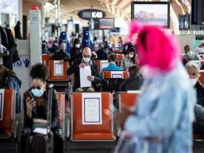 Des voyageurs portant des masques de protection  à l'aéroport de Roissy-Charles-de-Gaulle, le 14 mai 2020 - Ian LANGSDON [EPA POOL/AFP/Archives]