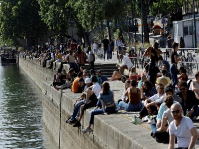 Des Parisiens prennent le soleil sur les berges de la Seine, le 19 mai 2020 - THOMAS COEX [AFP]
