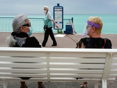 Conversation sur un banc sur la Promenade des Anglais, à Nice, le 16 mai 2020 - VALERY HACHE [AFP]