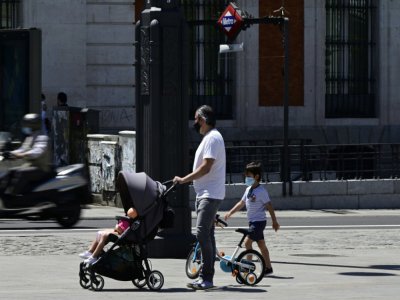 Un père de famille et ses enfants masqués, à Madrid le 21 mai 2020 - JAVIER SORIANO [AFP]