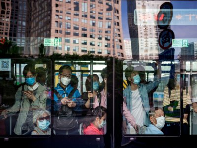 Des Chinois portent un masque de protection dans un bus à une heure de pointe matinale, le 22 mai 2020 à Pékin - NICOLAS ASFOURI [AFP]