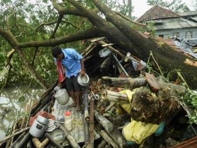 Un homme récupère des ustensils de cuisine dans les décombres de sa maison après le passage du cyclone Amphan, le 21 mai 2020 à Midnapore, en Inde - Dibyangshu SARKAR [AFP]