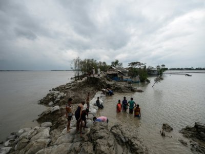 Des habitants tentent de consolider une digue après le passage du cyclone Amphan, le 21 mai 2020 à Burigoalini, au Bangladesh - Munir uz Zaman [AFP]