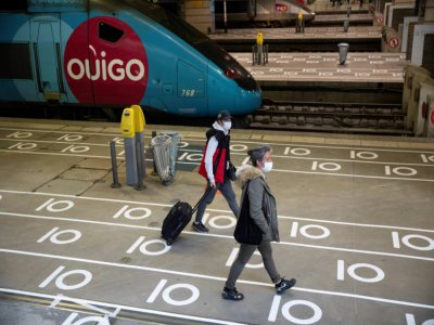 Des passagers sur les quais à la gare Montparnasse à Paris, le 12 mai 2020 suivent les marquages au sol de distanciation sociale - Thomas SAMSON [AFP/Archives]