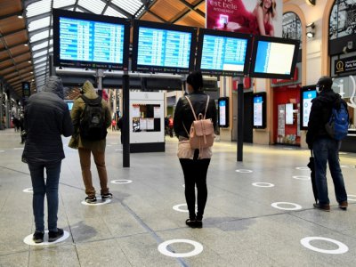 Des passagers à la gare Saint-Lazare à Paris, le 11 mai 2020 respectent les marquages au sol de distanciation sociale - BERTRAND GUAY [AFP/Archives]