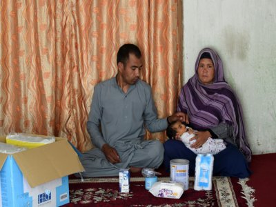Hasan Ali, 32 ans, sa femme Zia Gul, 28 ans et leur petite fille Roya, victimes de l'attaque de la maternité, dans leur maison de Kaboul où ils ont reçu l'aide matérielle d'une ONG, le 22 mai 2020 - WAKIL KOHSAR [AFP]