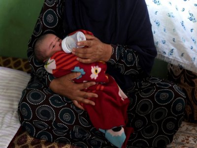 Le nouveau-né Mohmmad Ali, dans les bras d'un membre de sa famille, après la mort de sa mère, tuée dans l'attaque de la maternité où elle venait d'accoucher, ici dans un lieu près de Kaboul le 22 mai 2020 - WAKIL KOHSAR [AFP]