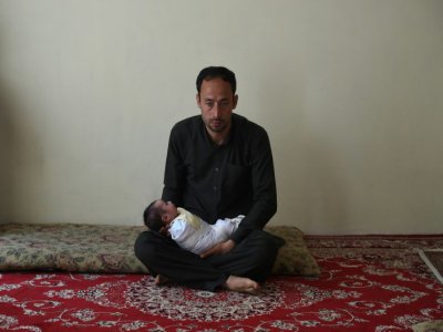 Akram, 40 ans, dont la femme a été tuée dans l'attaque de la maternité de Kaboul, tient sa fille Maryam, le 22 mai 2020 - WAKIL KOHSAR [AFP]