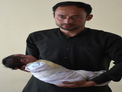 Akram, qui a perdu sa femme dans l'attaque de la maternité, à Kaboul avec sa fille Maryam le 22 mai 2020 - WAKIL KOHSAR [AFP]